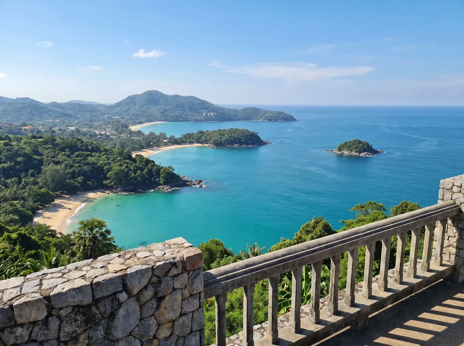 Taş korkuluğun ardından yeşil burunlarla ayrılmış Phuket koyları.