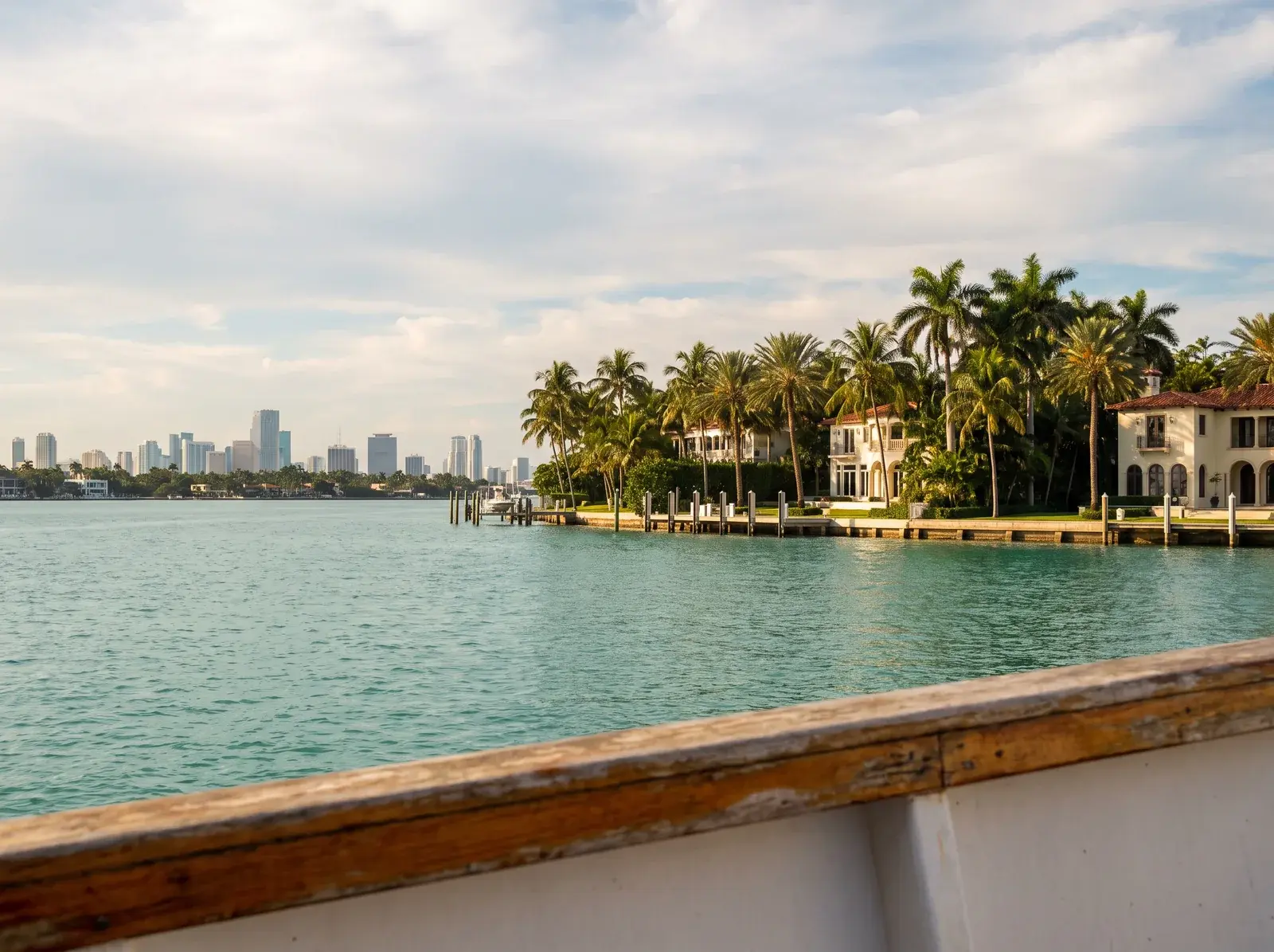 Tekneden görülen Biscayne Körfezi, palmiye ağaçlı malikâneler ve Miami silüeti.