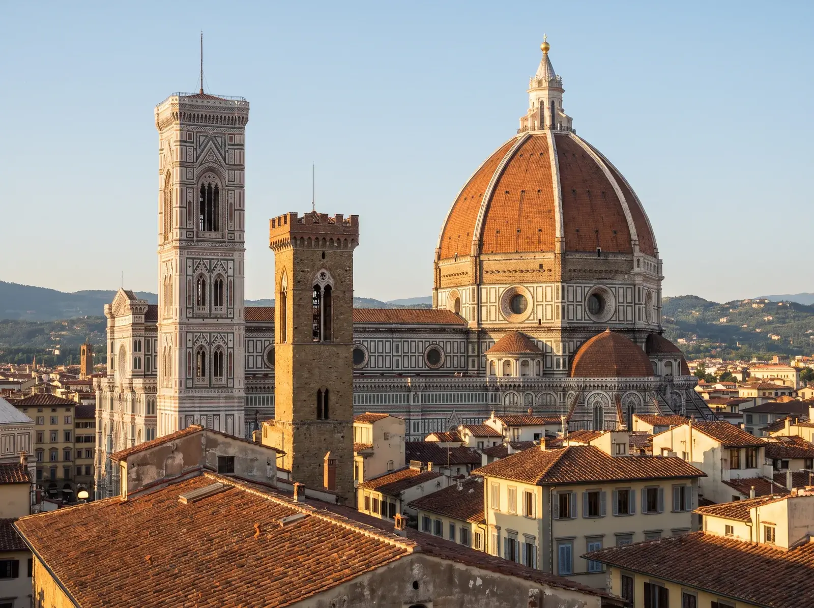 Floransa Duomo'nun kiremit renkli kubbesi ve çan kulesi, çatılar ile uzaktaki tepelerin önünde yükseliyor.
